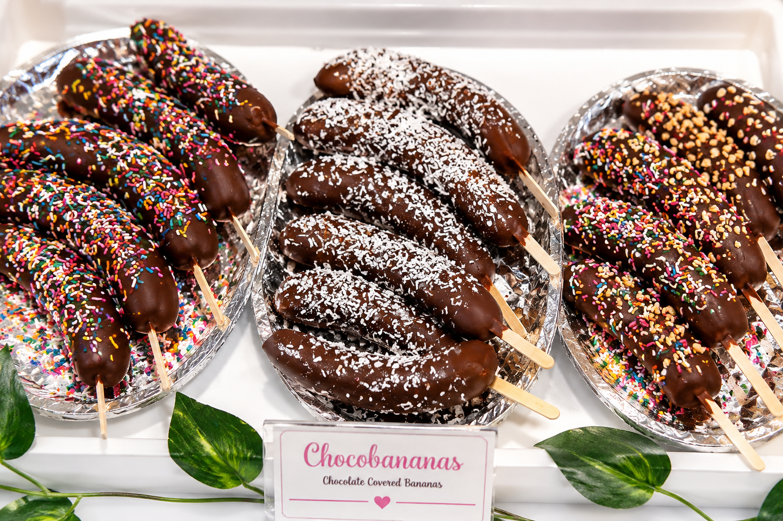 Full-size chocolate covered bananas with sprinkles, coconut, and peanut toppings