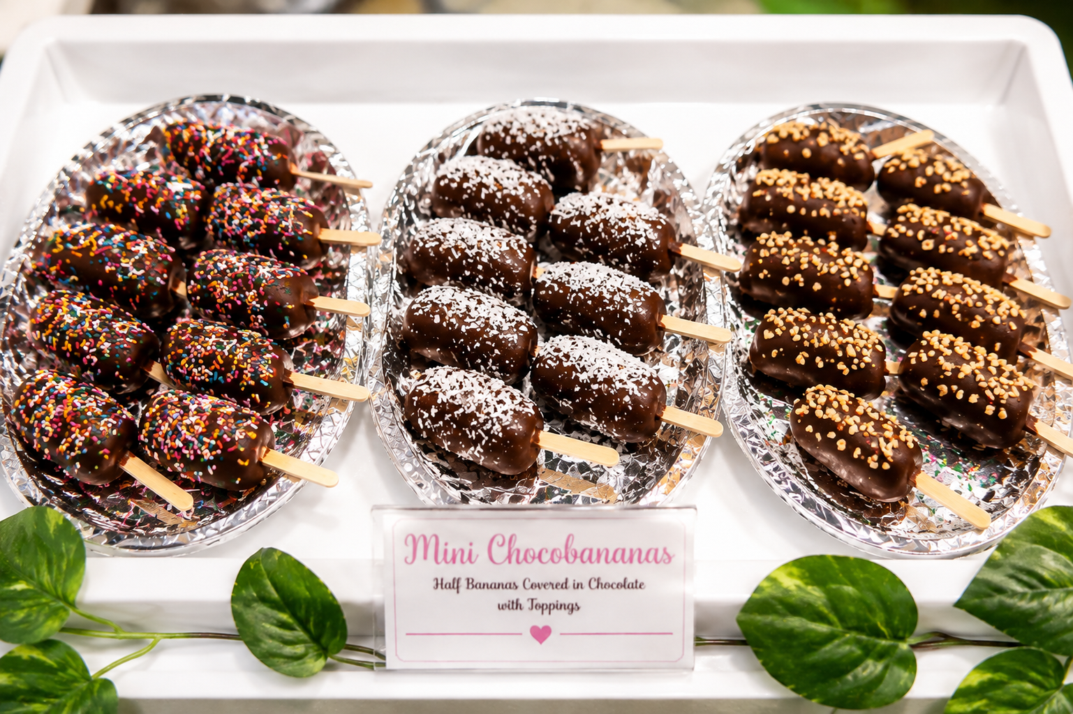 Mini chocobananas covered in chocolate with sprinkles, coconut, and peanut toppings