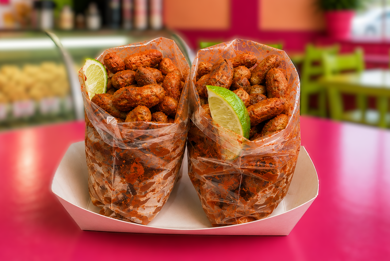 Two bags of boiled peanuts with chili powder and lime in a tray